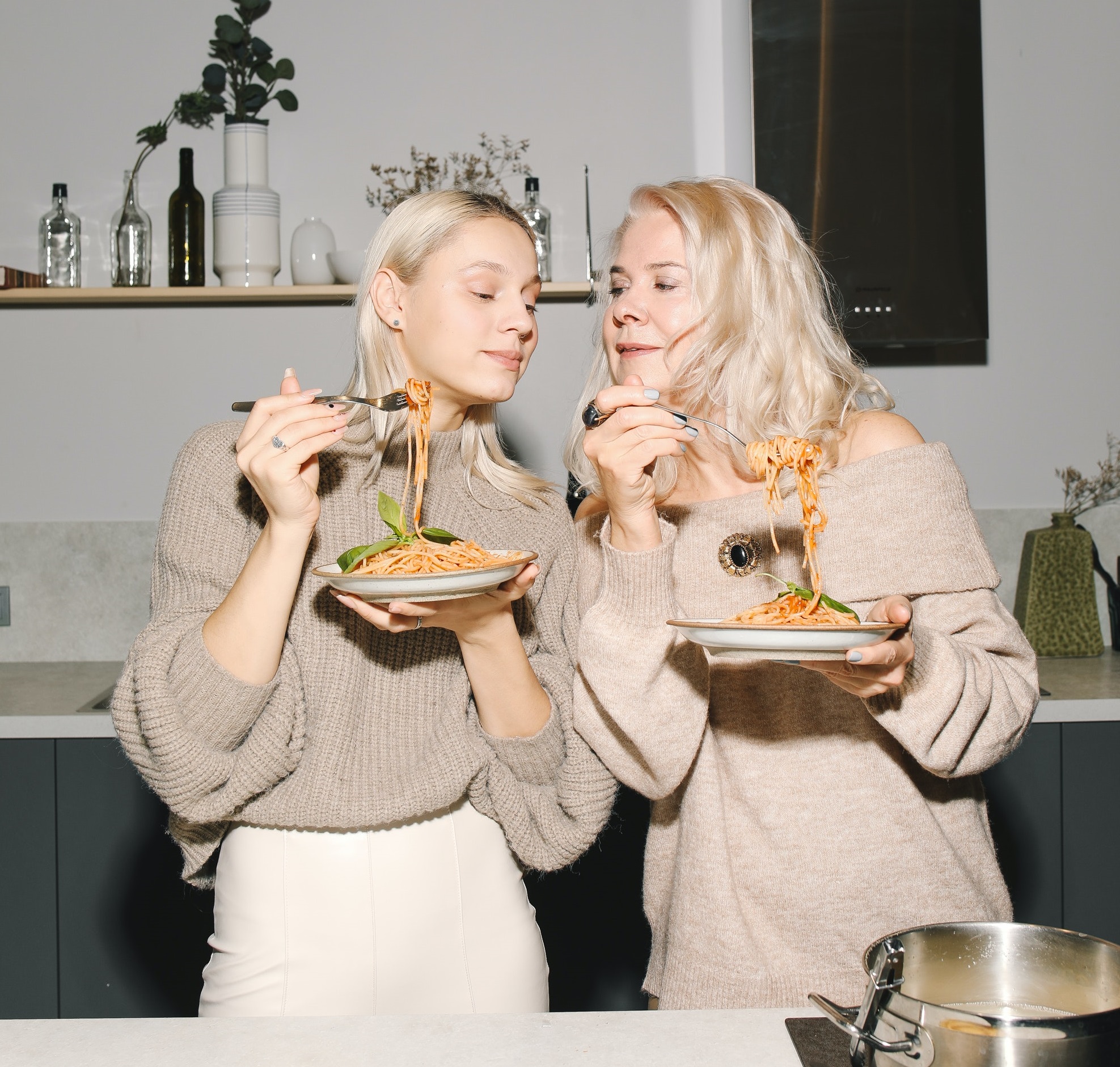 Two women enjoy pasta together